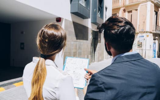 Architect reviewing blueprints with local officials during a building permit application process in the Dominican Republic.